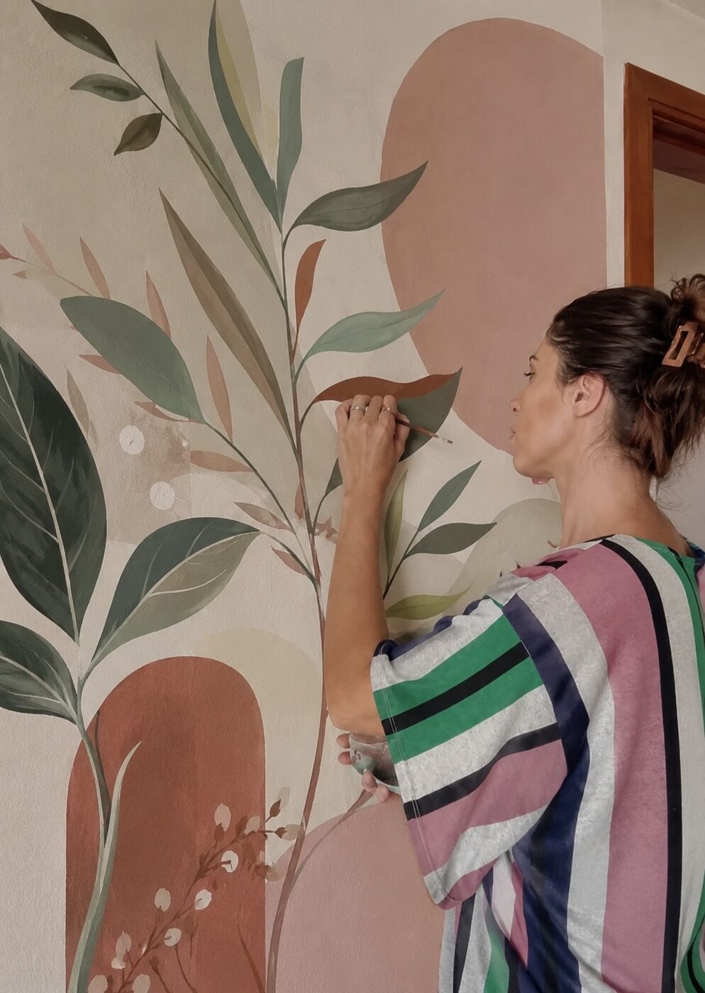Giovanna Peres pintando um mural autoral